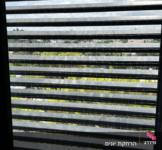 רשת מתכת על חלון למניעת כניסת יונים